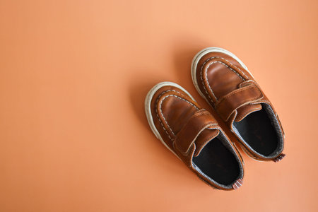 Pair of brown boy's shoes on colorful background. Top view.