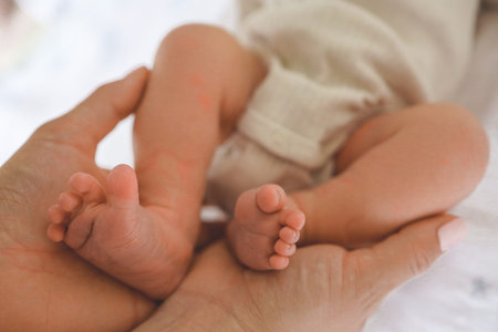 Baby feet in mother's hands. Mom and her Child. Happy Family concept. Beautiful conceptual image of...