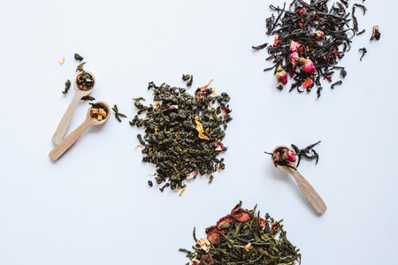 Herbal different types of tea and wooden spoons on white background top view.の写真素材