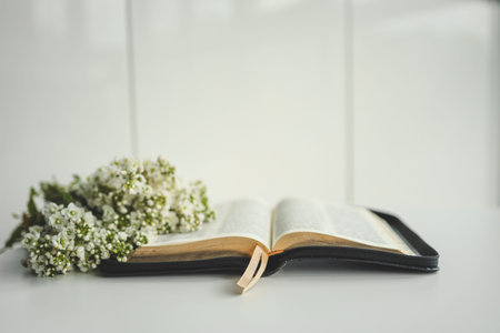 Open bible with flowers on a white background.