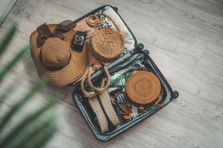 Vacation and travel concept. Suitcase, hat, bag and sunglasses on wooden floor.の写真素材