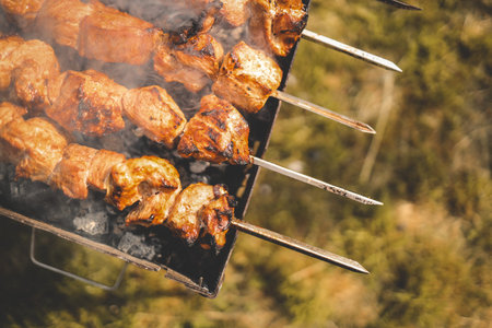 Man hand grilling barbecue with smoked pork at backyard on day. Family dinner outdoor style bbq...