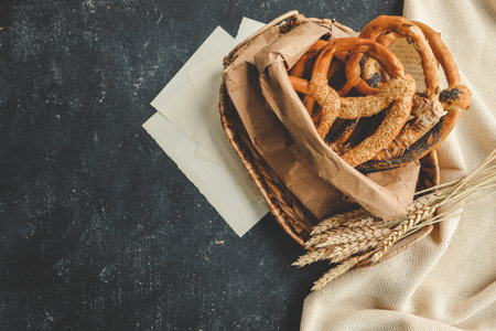 Fresh prepared homemade soft pretzels. Different types of baked pretzels with seeds on a black...