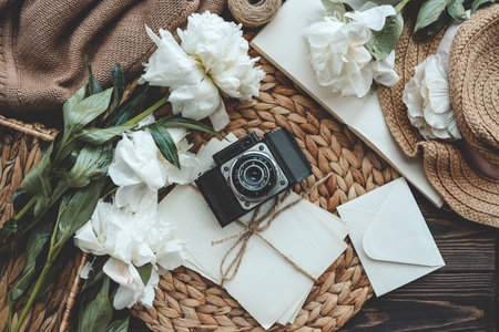 retro photo camera with book and fresh pink peony flowers.の写真素材