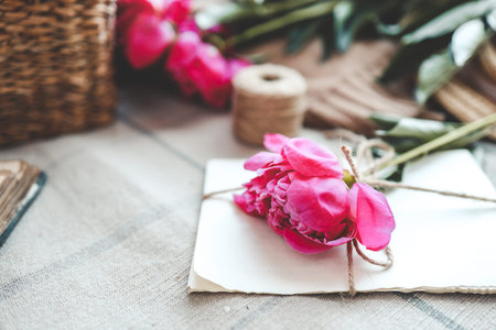 Craft letters and pink peony, spring composition.