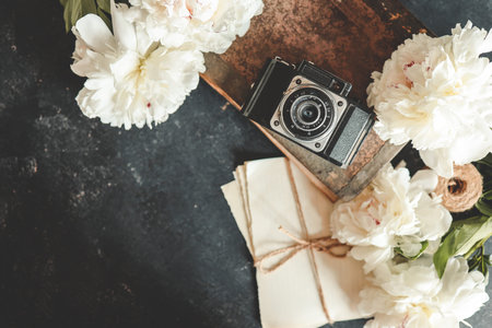 Summer background, flat lay layout, peonies and retro camera.