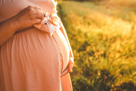 A pregnant woman holds cute baby shoes in her hands, the concept of expecting a baby.