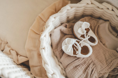 Knitted slippers and things for a newborn in the cradle.