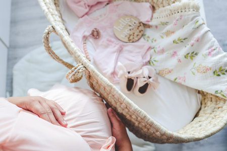 Pregnant woman near the cradle, the concept of expecting a baby.