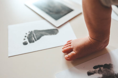 Baby footprints on white paper. Black footprint. The process of creating a baby footprint.