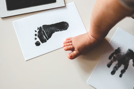 Baby footprints on white paper. Black footprint. The process of creating a baby footprint.