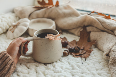 Hand with a cup of tea, good morning concept. Autumn mood.
