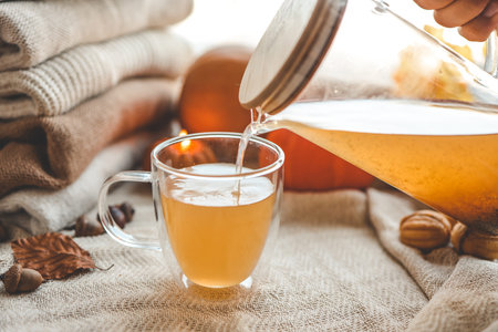 Teapot and cup with sea buckthorn tea, autumn mood.