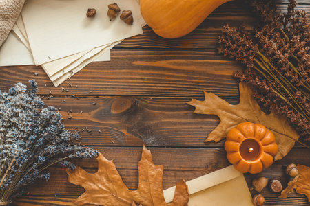 Autumn background top view, candle and leaves on wooden background.