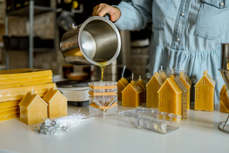The process of making candles, a woman pours wax into a mold.の写真素材