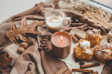 Burning candle with the smell of chocolate and cinnamon in a cozy home interior.