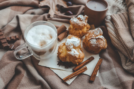 Cozy morning composition, cup of coffee, custard cakes and candle.