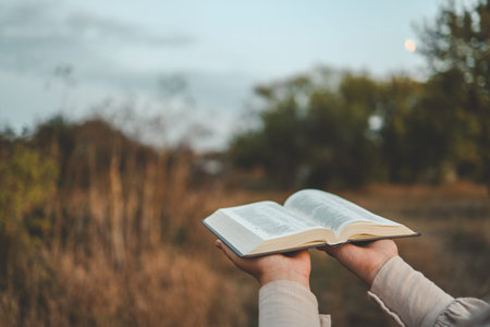 Bible in hands in nature, Christian concept.の写真素材