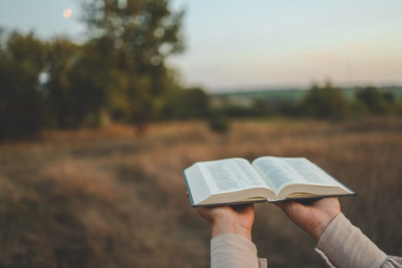 Bible in hands in nature, Christian concept.の写真素材