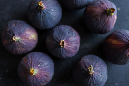 fresh ripe figs on dark background, top view