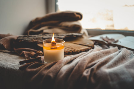 Burning candle in home interior, autumn aesthetics.
