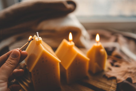 Handmade candles in the shape of a house in an autumn interior.の写真素材