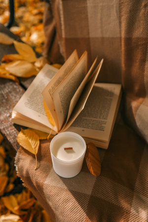 Candle and open book in nature, autumn concept.の写真素材