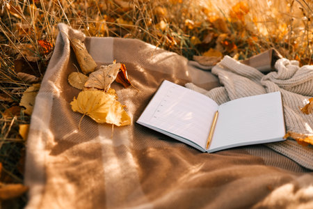 Paper planner on blanket outdoors, autumn concept.
