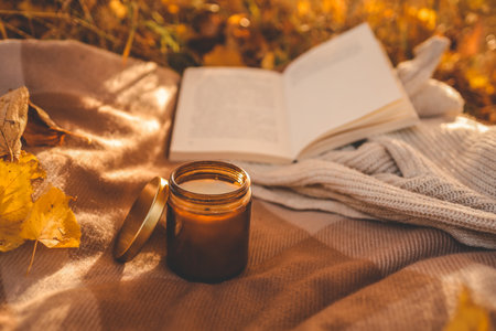 Candle and open book in nature, autumn concept.の写真素材