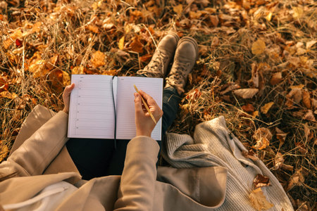 Girl with paper planner outdoors, autumn concept.