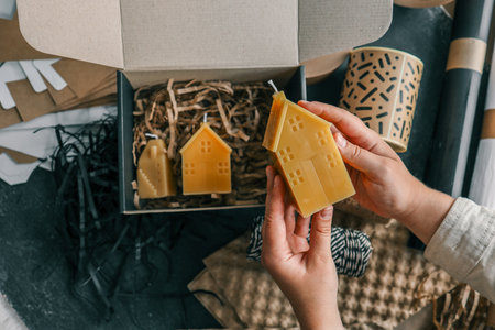 Handmade candle in hands, concept of packaging and delivery of goods.の写真素材
