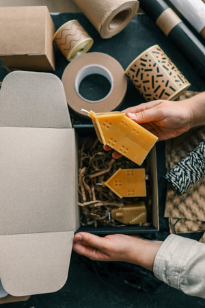 Handmade candle in hands, concept of packaging and delivery of goods.