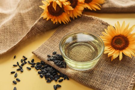 Sunflower oil, seeds and flower on yellow background.の写真素材