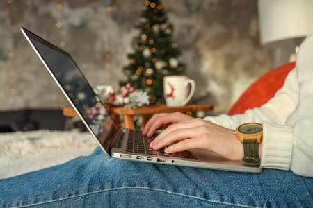 Close up of woman hands with, gifts, coffee cup and laptop. Online shopping at Christmas holidays. Freelance girl walking from home office. Female typing at notebook computer. Christmas moments.の写真素材