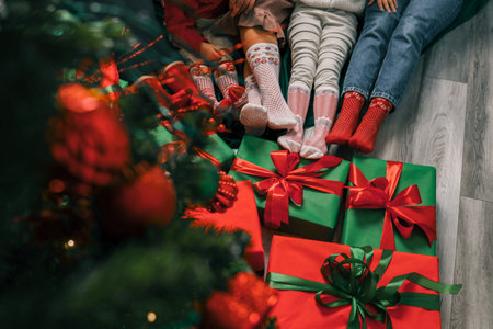 Feet wearing Christmas socks on wood floor. Happy family at home. Xmas holidays concept.の写真素材