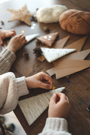 Children making Christmas decorations from yarn.