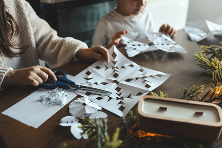 Children cut out snowflakes, Christmas activity.の写真素材