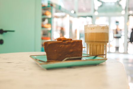 Chocolate cake and a cup of latte in a cozy coffee shop.の写真素材
