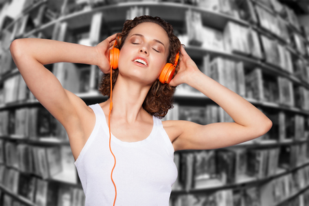 young beautifull woman listening to music with lots of CD in the backgroundの写真素材