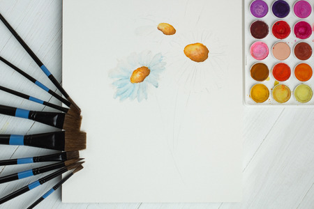 Paint brushes and empty sketchbookの写真素材