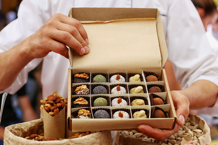 A man is holding a box of beautiful handmade candy.の写真素材