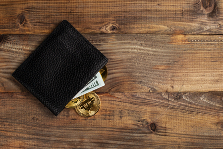 Money and Crypto-currency in the physical purse. The concept of virtual money in the wallet. On a wooden table.の写真素材