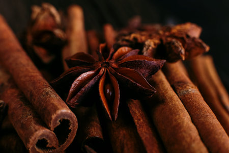 Spices sticks cinnamon and star anise on old table. Rustic dark background, aroma close-up, macro.