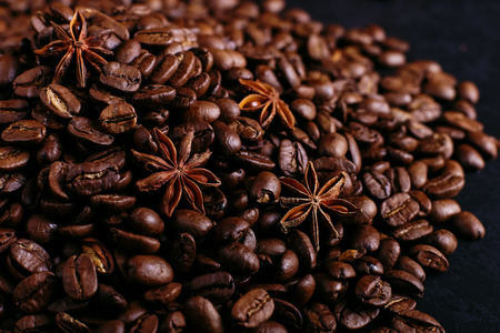 Star anise and coffee beans on kitchen table. Fragrant spices for coffee drink, closeup background.の写真素材