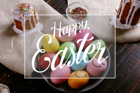 Easter baking with icing and colored powder and eggs. Preparing for the holiday on the kitchen table, on dark background.の写真素材