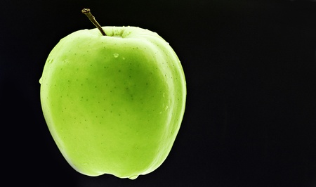Fresh green apple with waterdrops on blackの写真素材