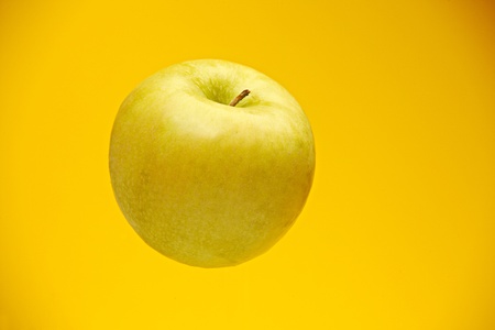Fresh green apple on yellow backgroundの写真素材