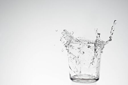 Water splash in drinking glass with bubble trailの写真素材