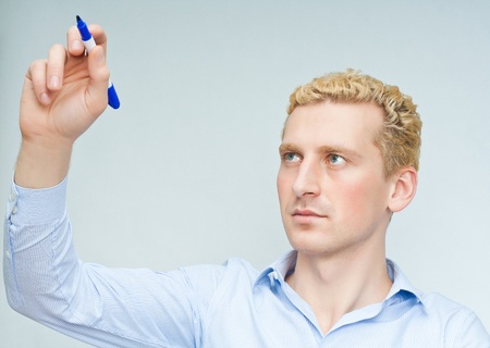 Businessman with marker isolated on gray background の写真素材