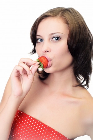 Portrait of young woman with bare shoulders holding ripe strawberryの写真素材